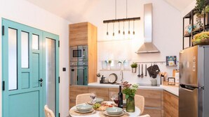 Cocina moderna con comedor, equipada con microondas, horno y refrigerador.