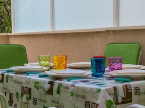 Ein Tisch ist mit Tellern, Gläsern und Besteck gedeckt und mit einer Tischdecke mit Mustern bedeckt.