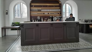 A modern kitchen with a central island, built-in shelves, and a view through arched windows. - Bach Dang Hotel (Hai Phong)