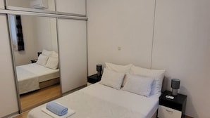Ett hotellrum med en säng, ett nattduksbord, en spegel och en luftkonditioneringsanläggning.