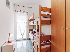 A bedroom with a bunk bed, a bedside table with a lamp, and a wardrobe. - Apartments Hak - Two Bedroom Apartment With Terrace and Sea View (Vir)