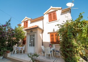A two-story building with a balcony, white walls, and wooden shutters. - Apartments Longo - Standard One Bedroom Apartment With Terrace, A3 - (Supetar)