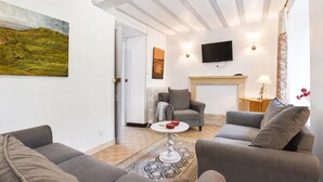 Ein Wohnzimmer mit Kamin, Flachbildfernseher und einem Bild an der Wand.