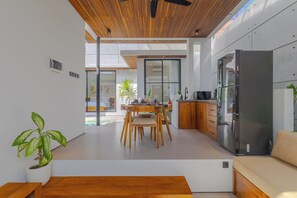 Une cuisine moderne dotée d’un grand réfrigérateur, de meubles en bois et d’un coin repas avec une table et des chaises.