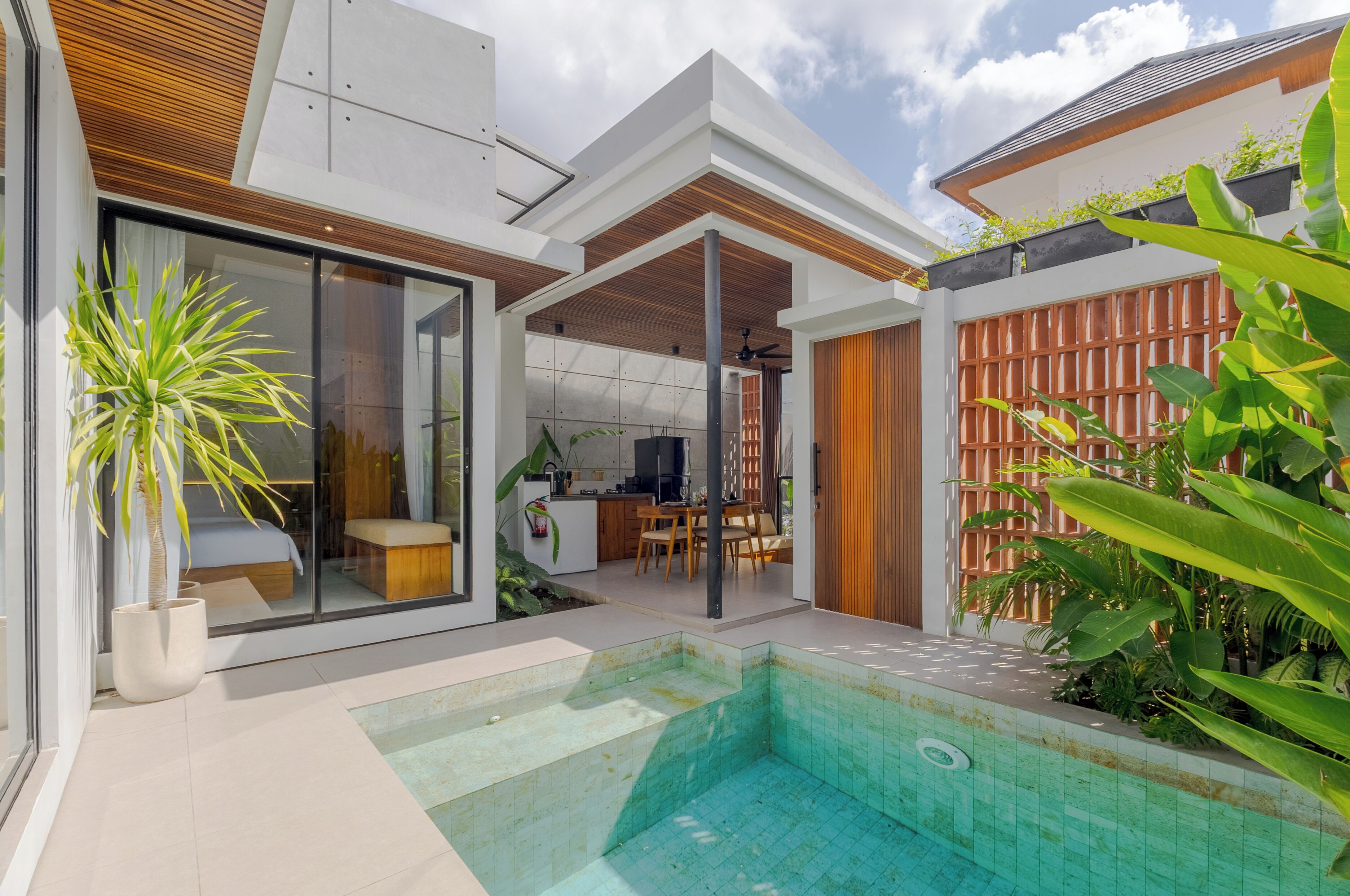 Ein modernes Haus mit Schwimmbad, Essbereich und Küche.