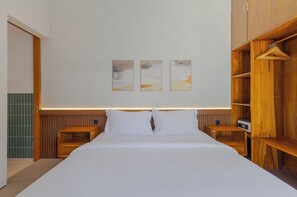 Ein modernes Schlafzimmer mit einem großen Bett, einem Holzkopfende, Nachttischen und einem Schrank aus Holz.