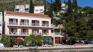 A coastal building with balconies, a stone facade, and a view of the sea. - Villa Malfi-studio Apartment With Balcony and Sea View (Dubrovnik)