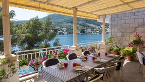 A terrace with a checkered tablecloth, chairs, and potted plants. - Villa Malfi-studio Apartment With Balcony and Sea View (Dubrovnik)