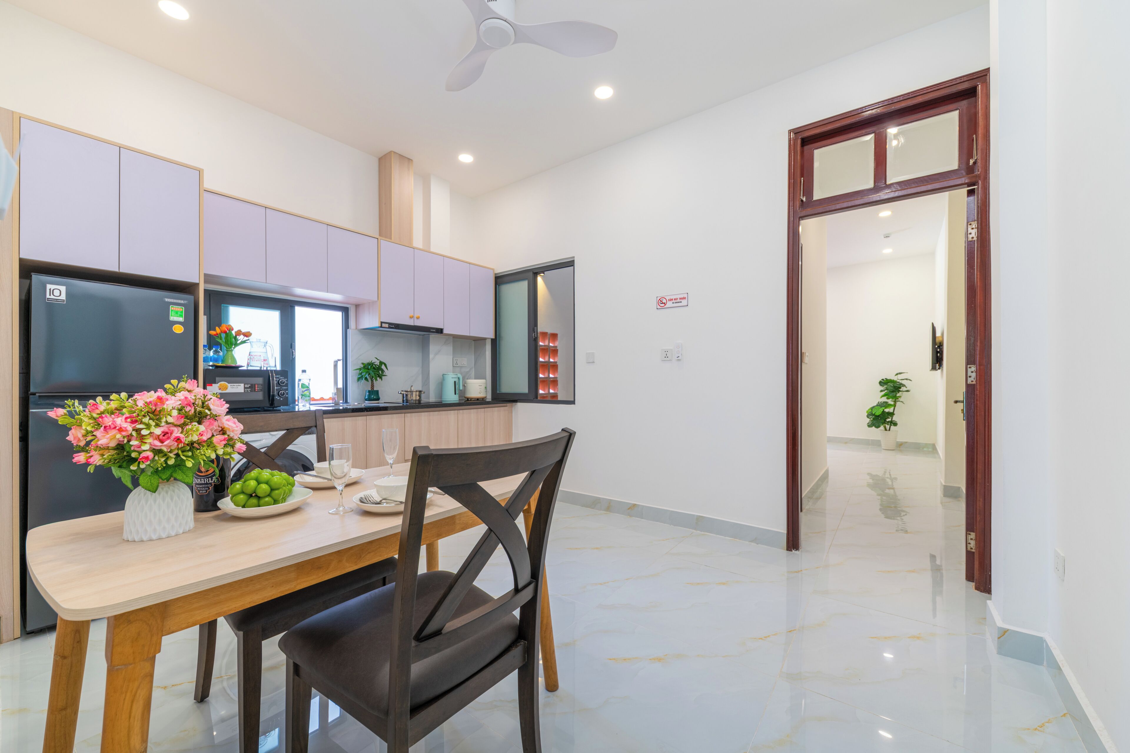 Una cocina moderna con una mesa de comedor, sillas y un ventilador de techo.