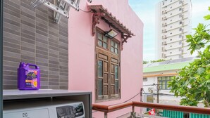 A residential balcony with a washing machine, a purple detergent bottle, and a metal drying rack. - LINH KHANG 2 APARTMENT DA NANG (Da Nang)