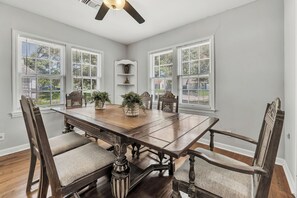 A dining room with a wooden table, four chairs, and a ceiling fan. - Watership Down: 45 Seconds from Texas A&M Campus (College Station)