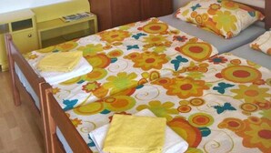 Ein Schlafzimmer mit einem Bett, einem Holzschrank, einem Nachttisch und einem kleinen Tisch.