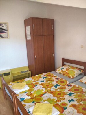 Ein Schlafzimmer mit einem Bett, einem Holzschrank, einem Nachttisch und einem kleinen Tisch.