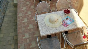 Eine Terrasse im Freien mit Whirlpool, Tischen und Stühlen.