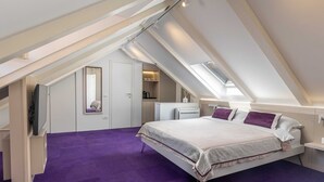 A bedroom with a sloped ceiling, a bed with pillows, a radiator, and a mirror. - Rooms Lejletul - Double Room (Dubrovnik)