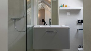 A modern bathroom with a glass shower enclosure, a white vanity, and a skylight. - Rooms Lejletul - Double Room (Dubrovnik)