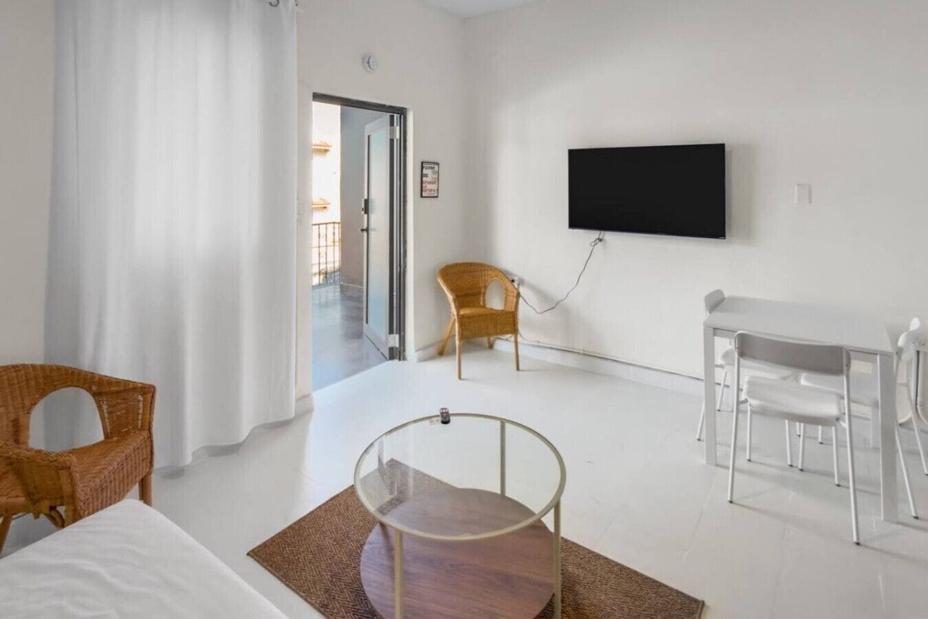 Ein Hotelzimmer mit Bett, Schreibtisch, Stuhl, Fernseher und Blick ins Freie.