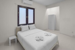 A minimalist bedroom with a bed, a small bedside table, a wardrobe, and a window. - Casa Magnolia Apt 7 | Santurce Multifamily House (San Juan de Puerto Rico)