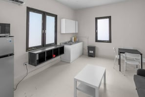 A modern kitchen with a built-in microwave, a white cabinet, and a window. - Casa Magnolia Apt 7 | Santurce Multifamily House (San Juan de Puerto Rico)