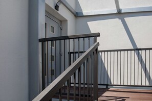A staircase with a metal railing leading to a door, a window, and a white wall. - Apartments Dva Galeba - Premium One Bedroom Apartment With Sea View (Bol)