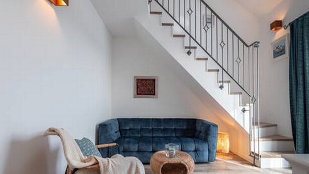 A modern living room with a blue sofa, a chair, a coffee table, and a staircase. - Luxury Room With Sea View (Trogir)