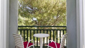 A balcony with two white chairs and a small round table, overlooking a tree. - Apartments Matusko Mljet - One Bedroom Apartment With Balcony and Sea View (Mljet)