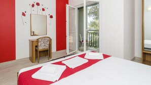 A hotel room with a bed, a chair, a desk, a mirror, and a balcony. - Apartments Matusko Mljet - One Bedroom Apartment With Balcony and Sea View (Mljet)
