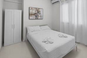 A bedroom with a bed, a wardrobe, and a painting on the wall. - Casa Magnolia Apt 4 | Santurce Multifamily House (San Juan de Puerto Rico)