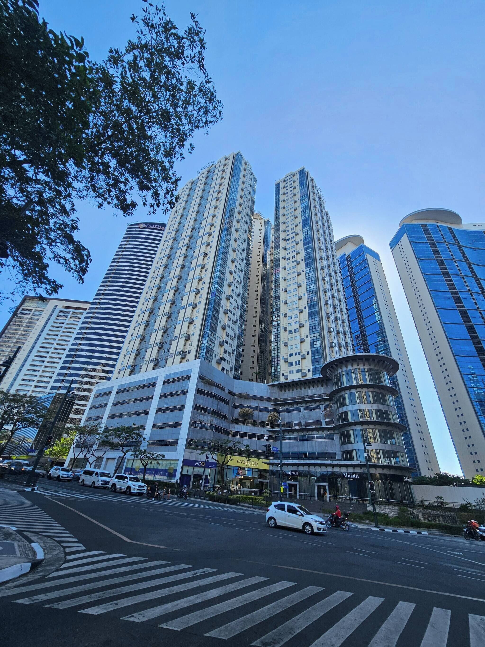 A multi-story building with a modern architectural design, featuring a mix of glass and concrete facades.