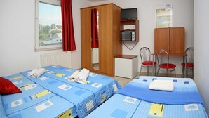 A room with two beds, a desk, a wardrobe, a television, and a chair. - Apartments & Rooms Villa Petra - Double Room (Sibenik)