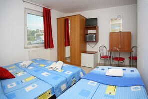 A room with two beds, a desk, a wardrobe, a television, and a chair. - Apartments & Rooms Villa Petra - Double Room (Sibenik)