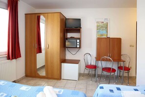 A room with a wardrobe, a television, a microwave, a desk, two chairs, and a bed. - Apartments & Rooms Villa Petra - Double Room (Sibenik)