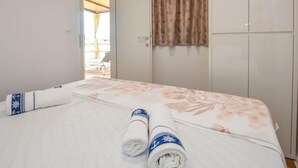 A hotel room with a bed, a wardrobe, and a view of an outdoor area. - Mobile Homes Bella Vita 2 (Biograd na Moru)