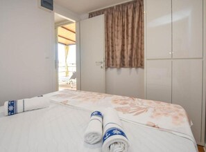 A hotel room with a bed, a wardrobe, and a view of an outdoor area. - Mobile Homes Bella Vita 2 (Biograd na Moru)