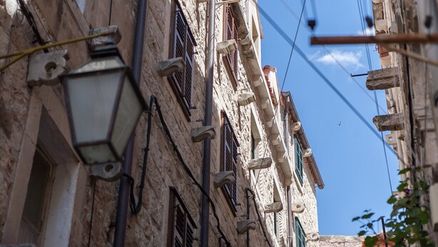 A narrow street with old buildings, a street lamp, and a clear blue sky. - Apartments Noa Old Town - Studio - Ground Floor (Dubrovnik)