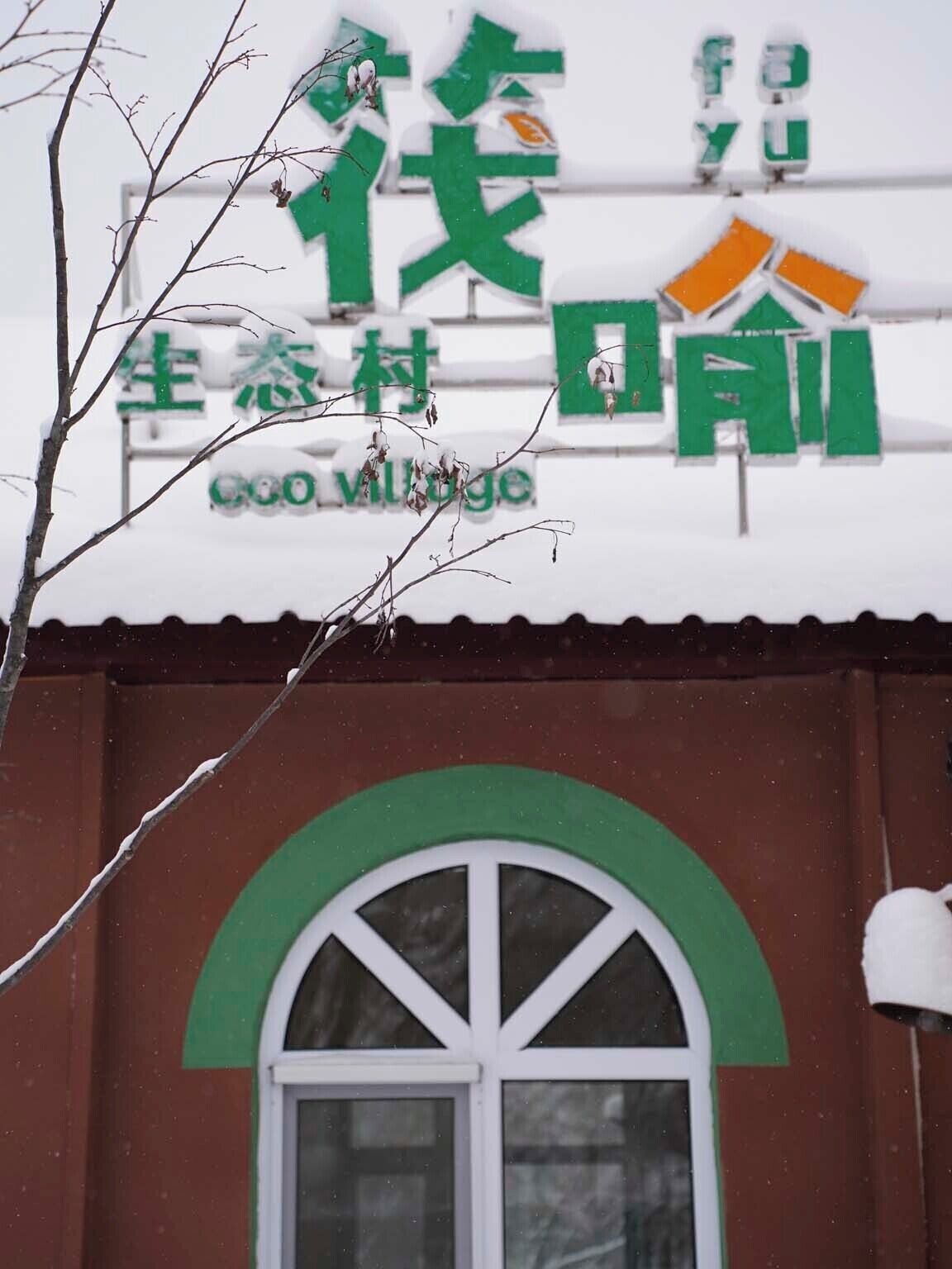 Un bâtiment avec une enseigne verte et blanche sur laquelle on peut lire « Goo Village ».