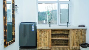 A kitchen with a built-in refrigerator, a sink, and a window above the counter. - FAYU-ecovillage (Yichun)