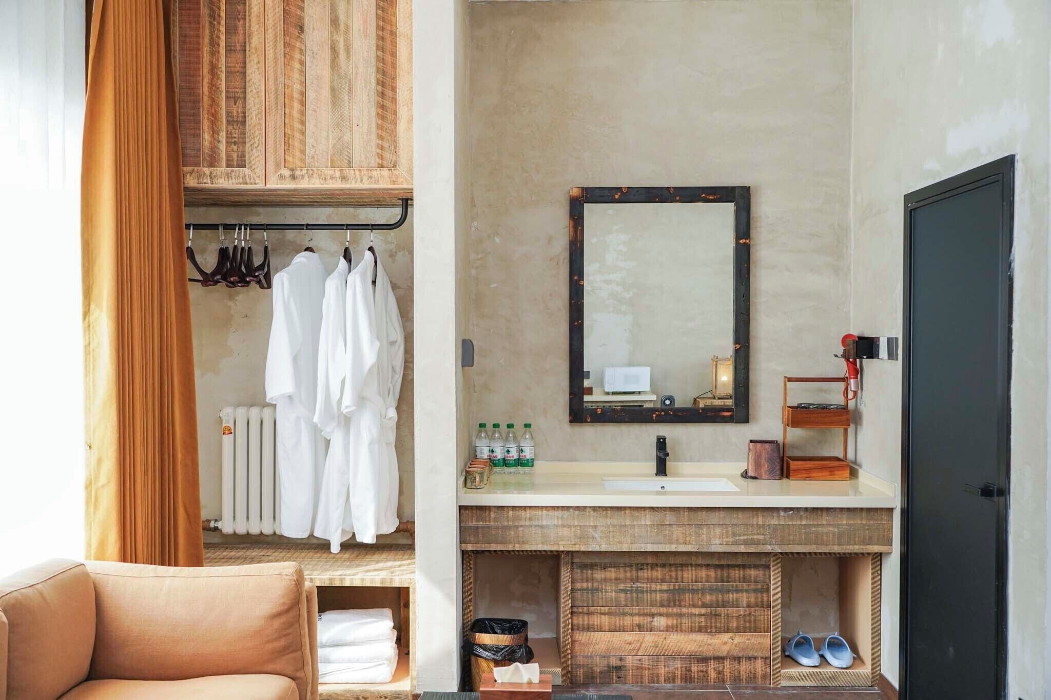 A bathroom with a wooden vanity, a mirror, and a towel rack.