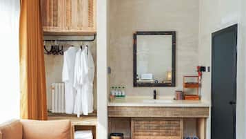 A bathroom with a wooden vanity, a mirror, and a towel rack.