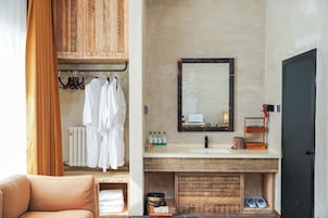 Un baño con tocador de madera, un espejo y un perchero para toallas.