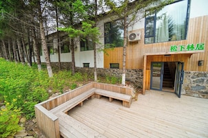 Un edificio moderno con terraza de madera y pared de piedra.
