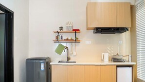 A compact kitchen with a refrigerator, a sink, and a microwave. - FAYU-ecovillage (Yichun)