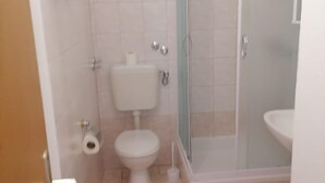 A bathroom with a toilet, a shower enclosure, and a sink. - Apartments Libertas - Studio With Balcony and Sea View - (Rogoznica)