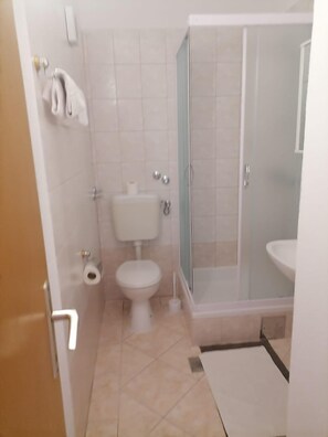 A bathroom with a toilet, a shower enclosure, and a sink. - Apartments Libertas - Studio With Balcony and Sea View - (Rogoznica)