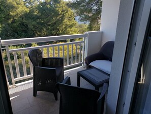 A balcony with a chair, a small table, and a sofa. - Apartments Libertas - Studio With Balcony and Sea View - (Rogoznica)