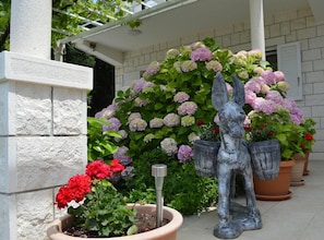 Un jardín con una estatua, plantas en macetas y la fachada de un edificio.