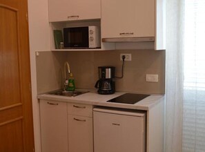 A compact kitchenette with a microwave, coffee maker, and a small refrigerator. - Apartments Spilan (Zupa dubrovacka)