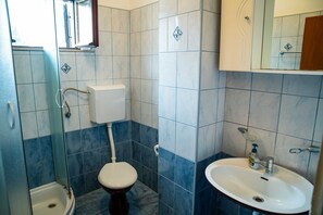 Ein Badezimmer mit Toilette, Waschbecken und Dusche.