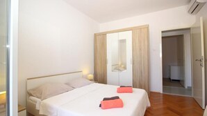 A bedroom with a bed, bedside tables, a wardrobe, and a mirror. - Apartment Dubreta With Balcony (Konavle)