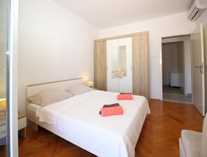 A bedroom with a bed, bedside tables, a wardrobe, and a mirror. - Apartment Dubreta With Balcony (Konavle)